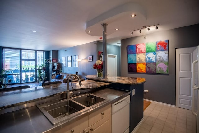 kitchen featuring open floor plan, light tile patterned flooring, white dishwasher, white cabinetry, and track lighting