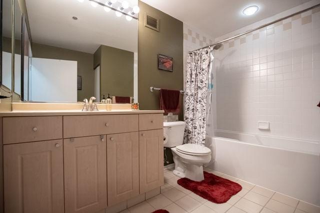 full bath featuring toilet, visible vents, vanity, tile patterned floors, and shower / bath combo