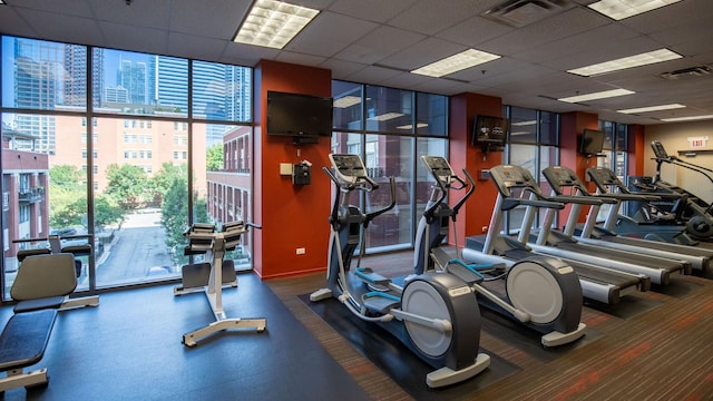 gym featuring expansive windows, a drop ceiling, and visible vents