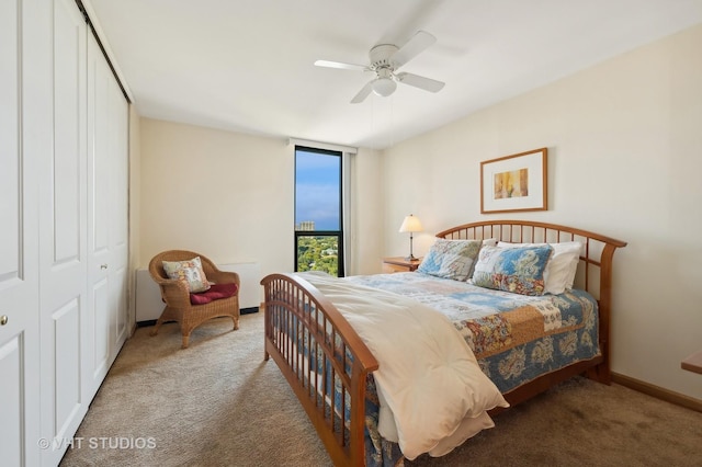 bedroom with carpet floors, ceiling fan, baseboards, and a closet