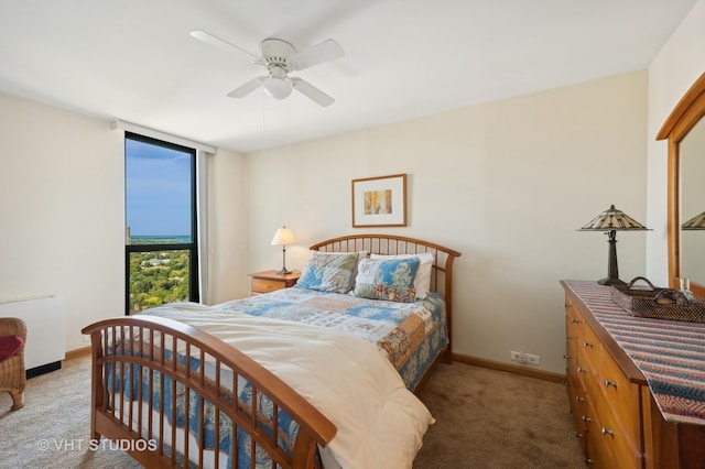 carpeted bedroom featuring baseboards and a ceiling fan