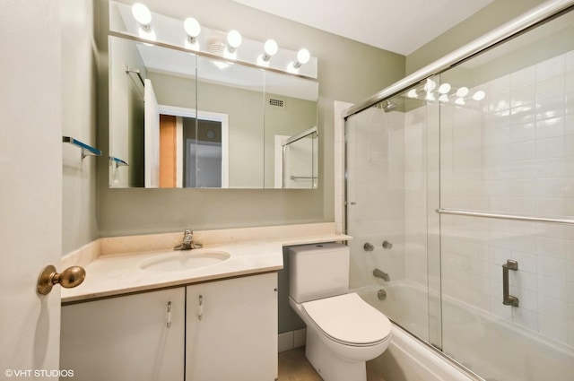 bathroom featuring toilet, bath / shower combo with glass door, visible vents, and vanity