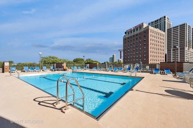 community pool featuring a patio area and fence