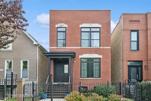 view of front of house featuring brick siding and a fenced front yard