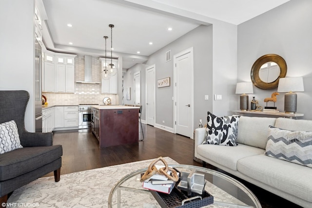 living area with dark wood finished floors, visible vents, recessed lighting, and baseboards