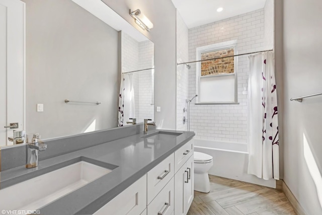 bathroom featuring a sink, toilet, double vanity, and shower / tub combo with curtain