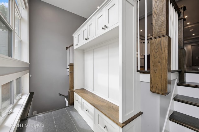 mudroom with dark tile patterned floors