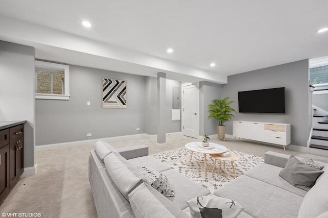 living area featuring recessed lighting, baseboards, light colored carpet, and stairs