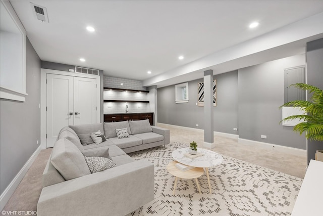 living area with recessed lighting, visible vents, and baseboards