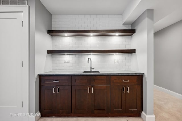 bar featuring a sink, visible vents, baseboards, and tasteful backsplash