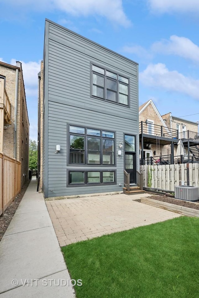 back of house featuring a yard, a patio, cooling unit, and fence