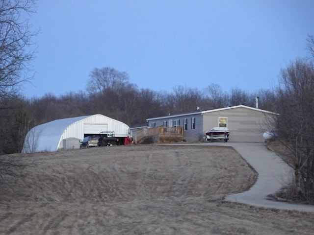 view of front of home featuring a garage, an outbuilding, and driveway