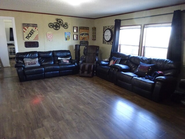 living room with a textured ceiling, wood finished floors, and crown molding
