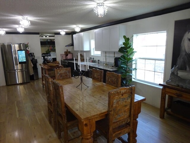 dining area featuring a textured ceiling and light wood-style flooring