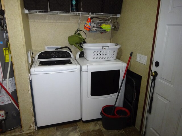 laundry room with washing machine and clothes dryer, laundry area, and water heater