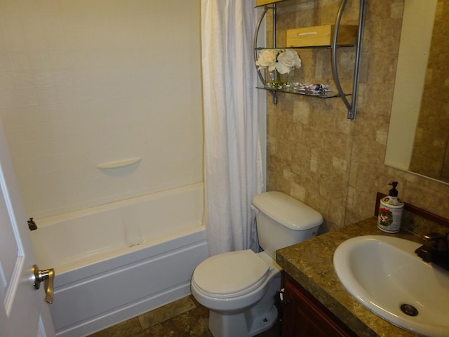 full bath with toilet, tile walls, shower / bath combo, and vanity
