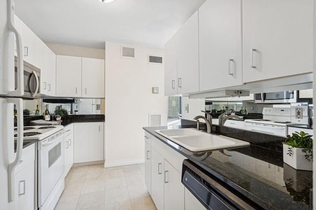 kitchen featuring white appliances, white cabinets, visible vents, and a sink