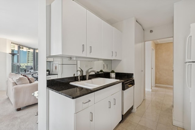 kitchen featuring a sink, white cabinetry, white appliances, light tile patterned floors, and baseboards