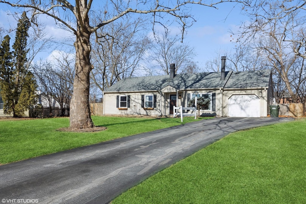535 Hazelwood Ln, Glenview, IL 60025 - view of front of house featuring driveway, a garage, fence, and a front yard