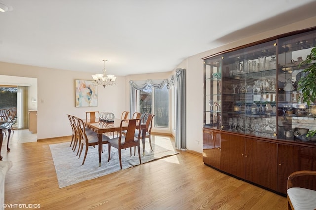 dining room featuring baseboards, a chandelier, and wood finished floors