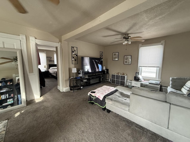 carpeted living area with a ceiling fan, a textured ceiling, and baseboards