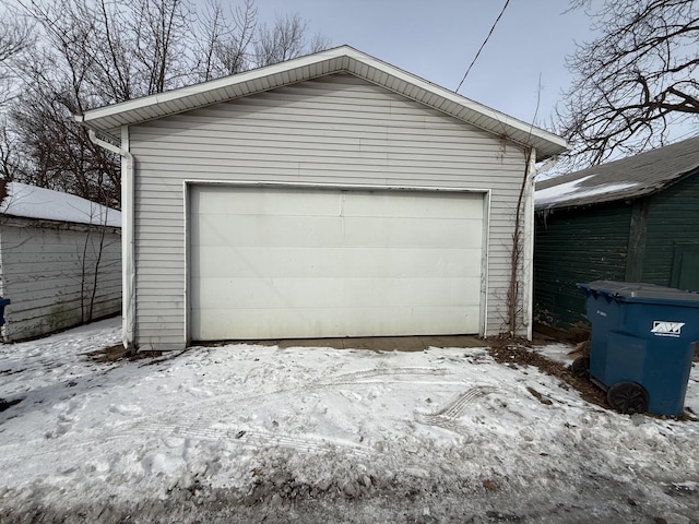 snow covered garage with a detached garage