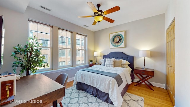 bedroom with light wood-style flooring, visible vents, and baseboards