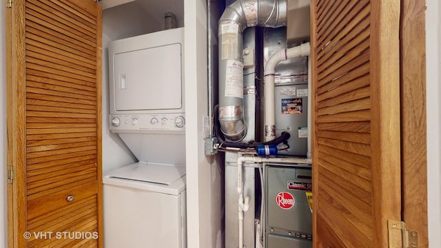 clothes washing area with stacked washer and clothes dryer and laundry area