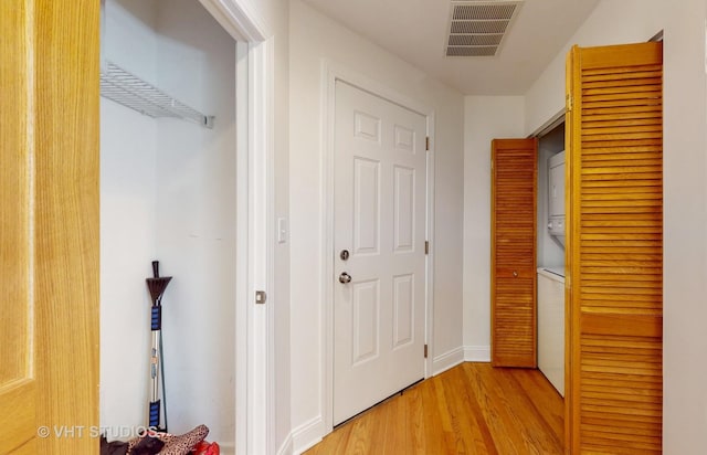 corridor with visible vents, baseboards, and wood finished floors