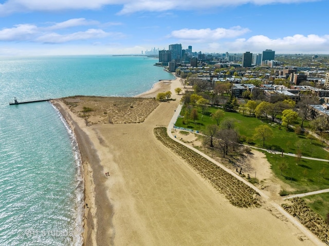 aerial view with a water view, a view of city, and a beach view