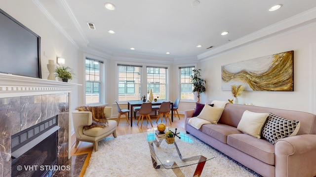 living room with recessed lighting, wood finished floors, a high end fireplace, and crown molding