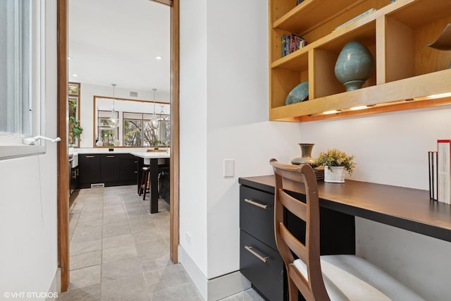 office space featuring built in study area, visible vents, and baseboards