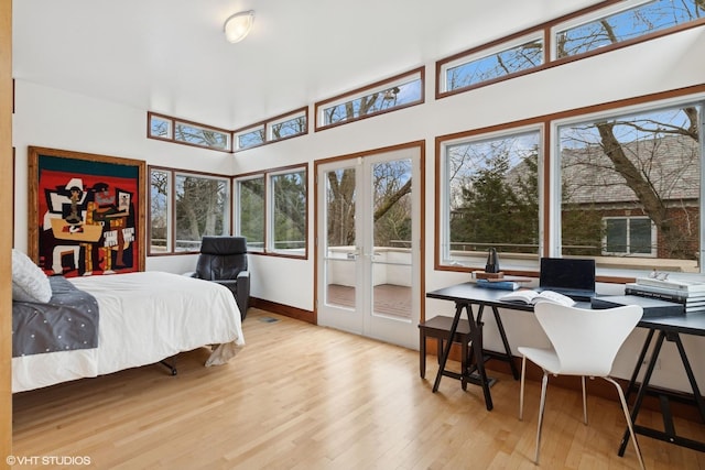 bedroom with baseboards, wood finished floors, and french doors