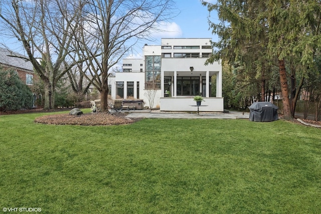 back of property with a lawn and stucco siding