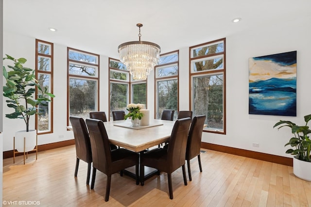 dining space featuring light wood-style flooring, baseboards, a notable chandelier, and recessed lighting