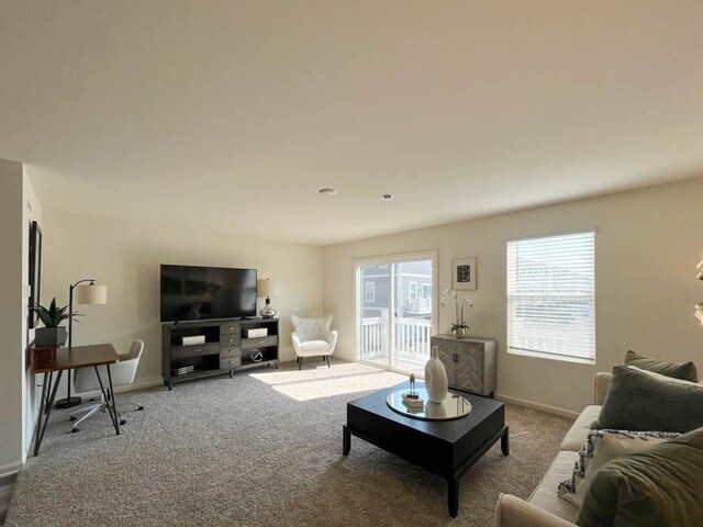 carpeted living area with baseboards