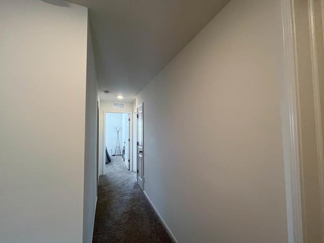 corridor with carpet, visible vents, and baseboards