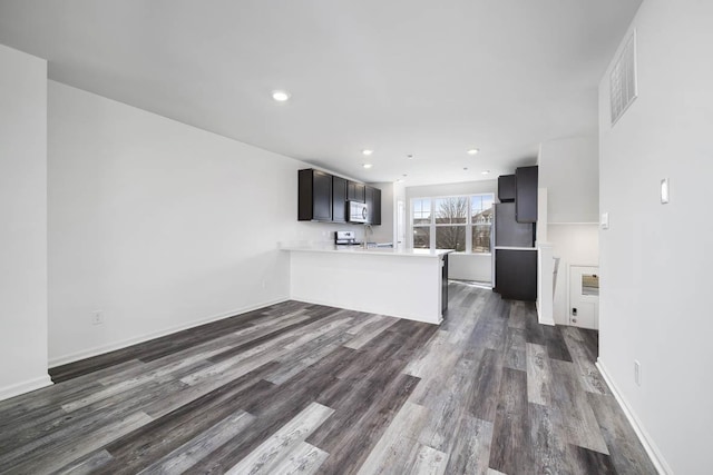 kitchen with visible vents, dark wood-type flooring, a peninsula, light countertops, and recessed lighting