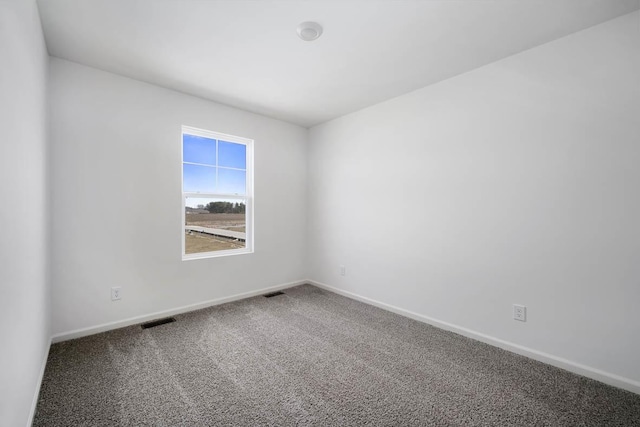 empty room featuring carpet floors, visible vents, and baseboards