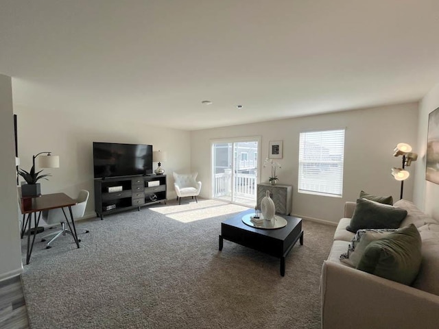 carpeted living room featuring baseboards