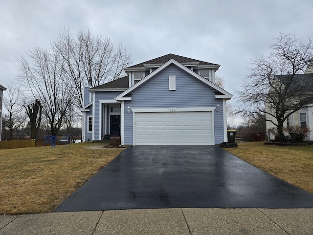 traditional-style home featuring an attached garage, aphalt driveway, and a front yard