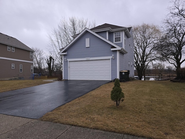 view of front of home with aphalt driveway, a front yard, and an attached garage