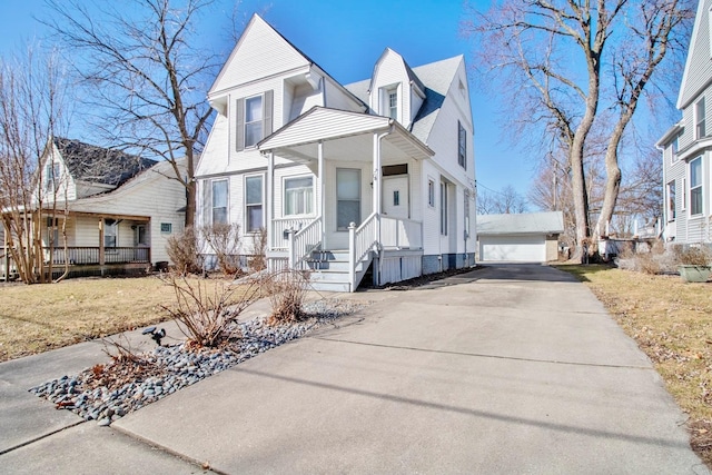 view of front facade featuring a garage, covered porch, a front lawn, and an outdoor structure