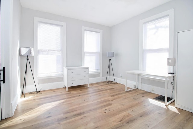 interior space with baseboards and light wood finished floors