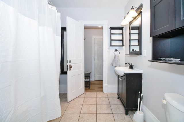 full bathroom featuring toilet, tile patterned flooring, baseboards, and vanity