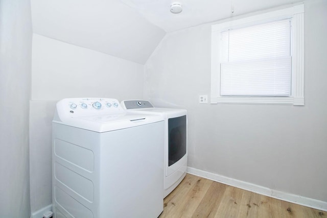 laundry room featuring laundry area, light wood-type flooring, washing machine and clothes dryer, and baseboards