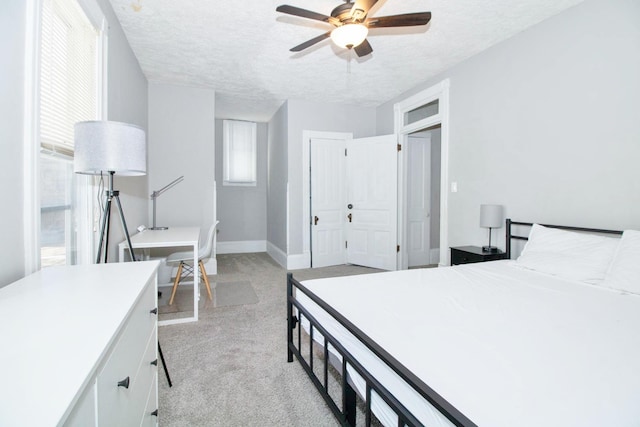 carpeted bedroom with a ceiling fan, baseboards, and a textured ceiling