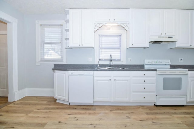 kitchen featuring white appliances, dark countertops, a sink, and under cabinet range hood