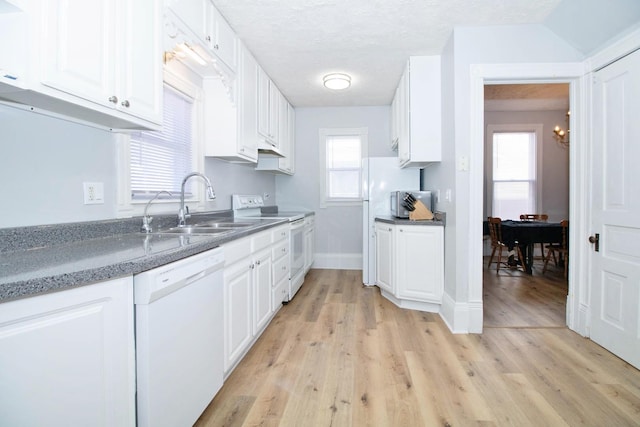 kitchen with white appliances, light wood-style flooring, and white cabinets