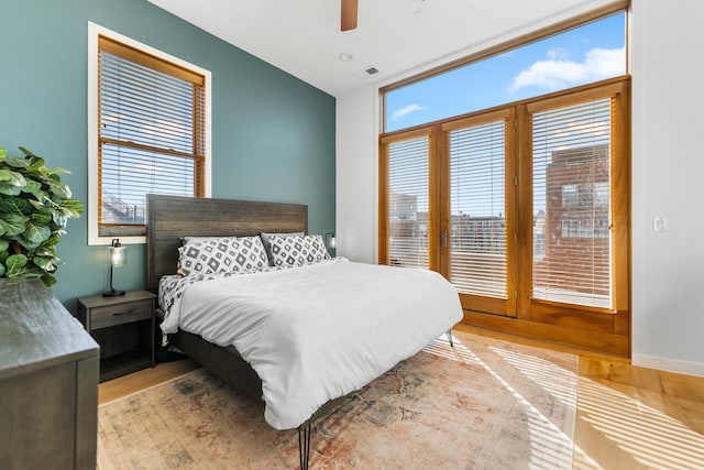 bedroom with ceiling fan, multiple windows, visible vents, and light wood-style flooring